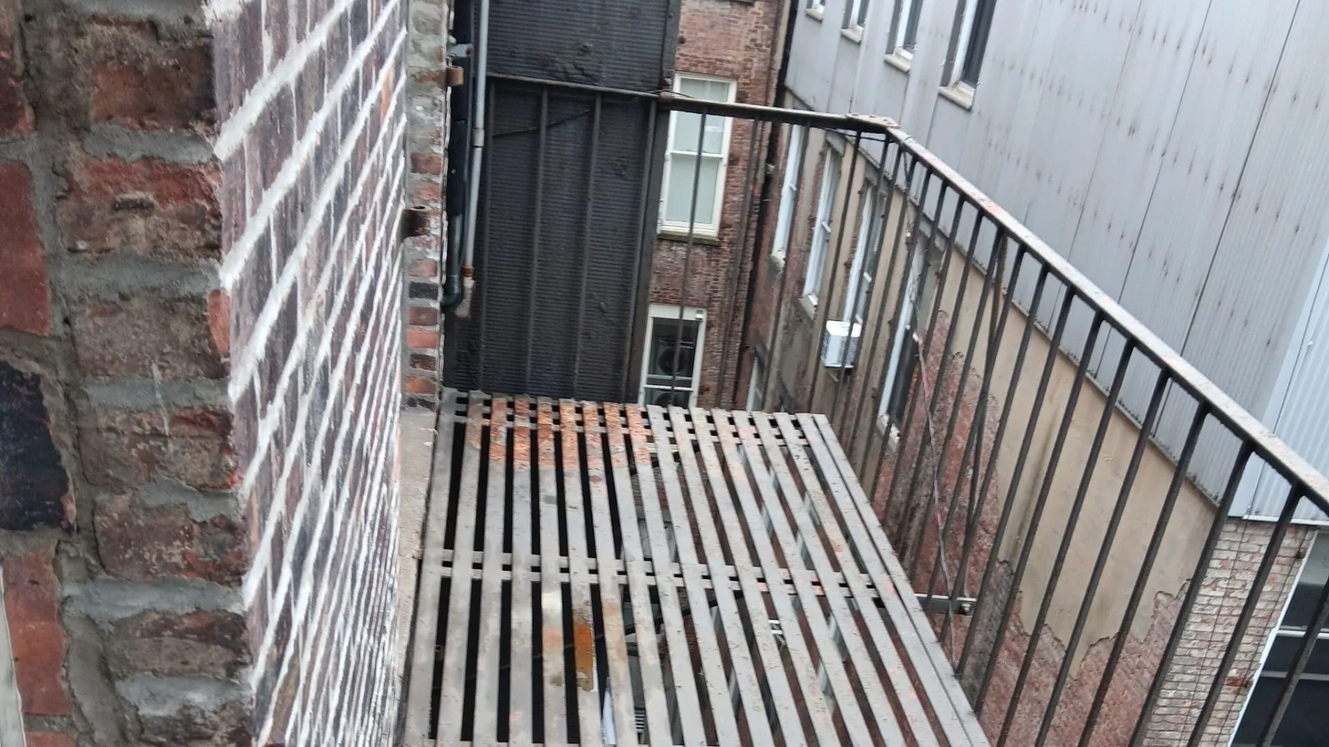 Inspector checking structural bolts on fire escape
